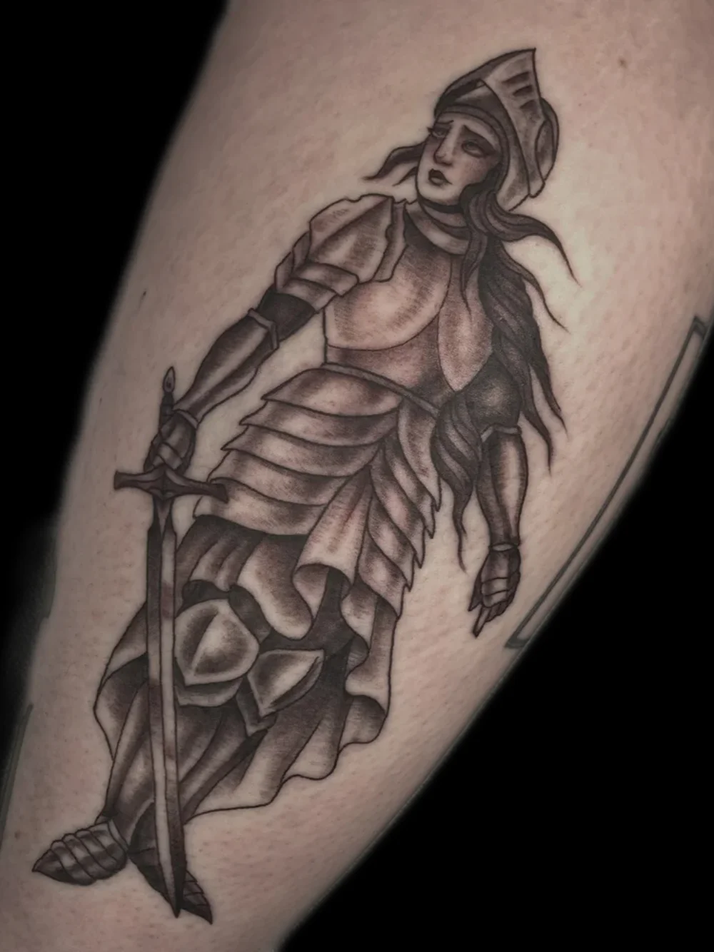 Female knight in armor tattoo, black and grey, on the calf